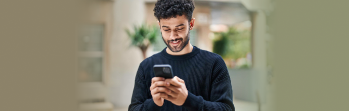 Man smiling while using a smartphone